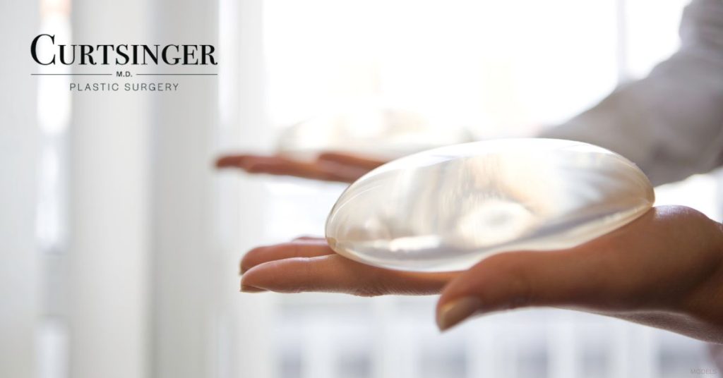 A person holding breast implant options. (Models)